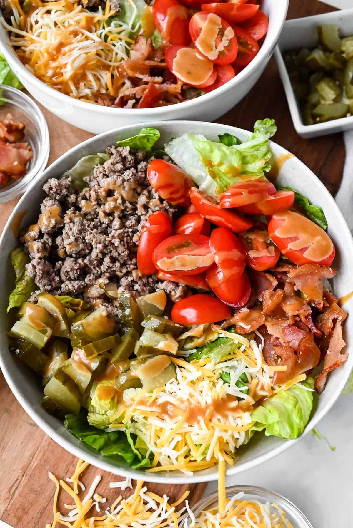 burger in a bowl with lettuce, bacon, tomatoes, cheese and special sauce