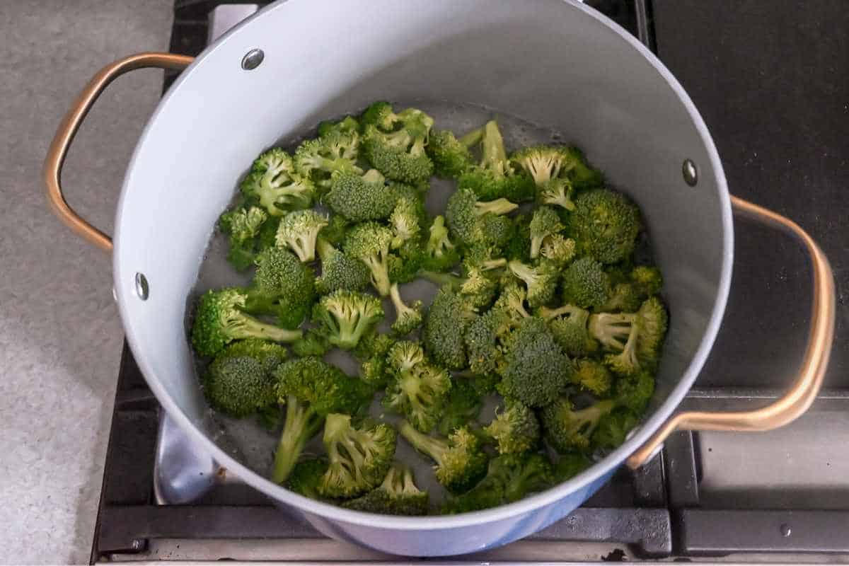 raw broccoli in boiling water in a pot.