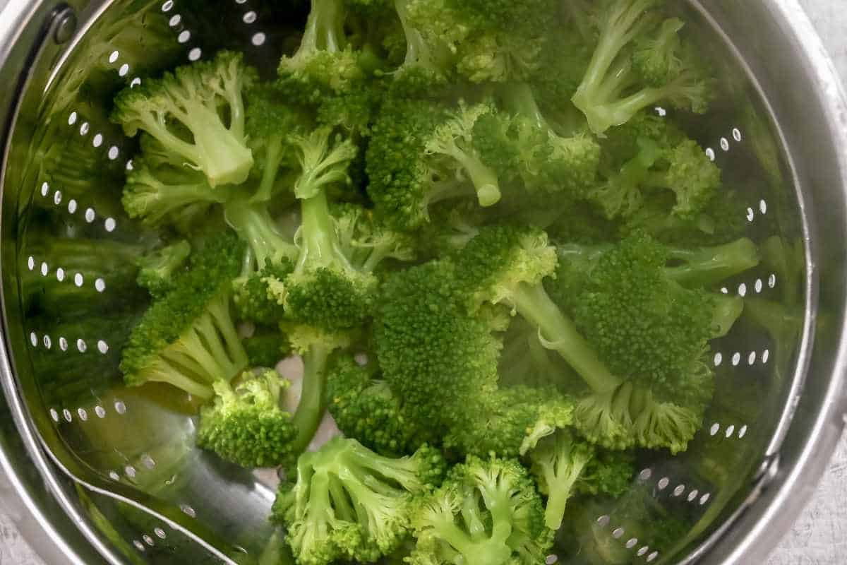 steamed broccoli in a colander.
