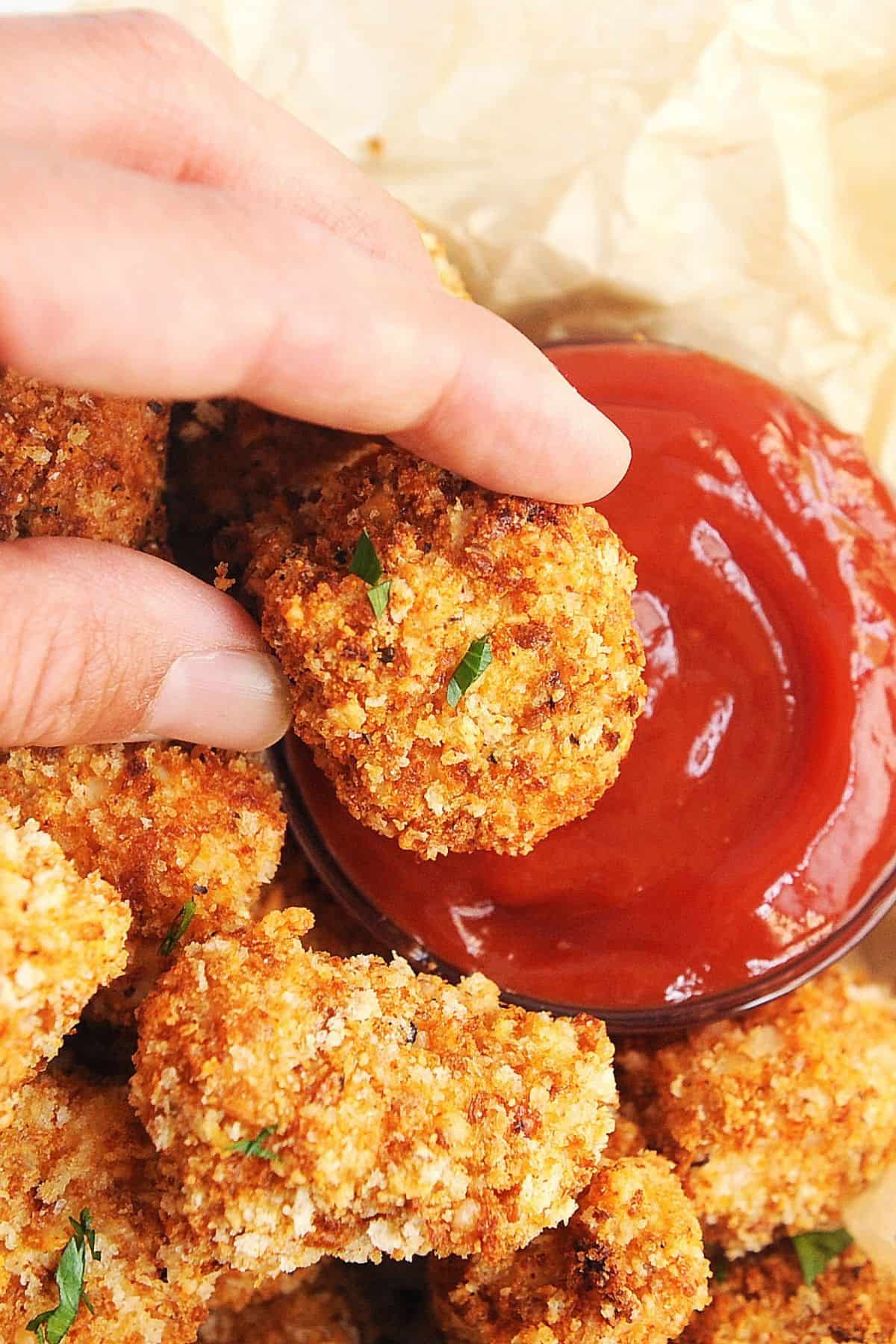 dipping air fried chicken nuggets in ketchup
