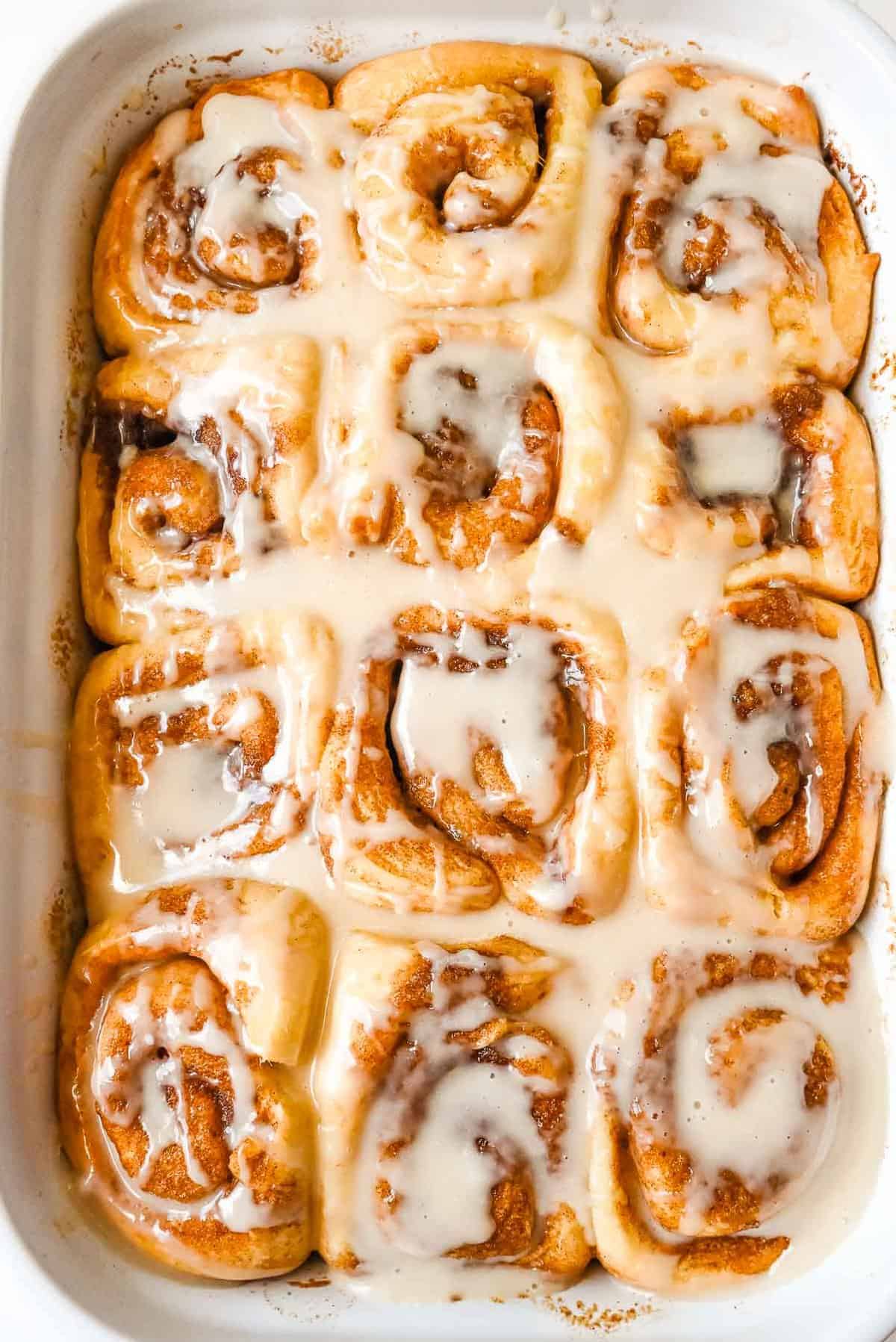 pan of dairy free cinnamon rolls covered in glaze.
