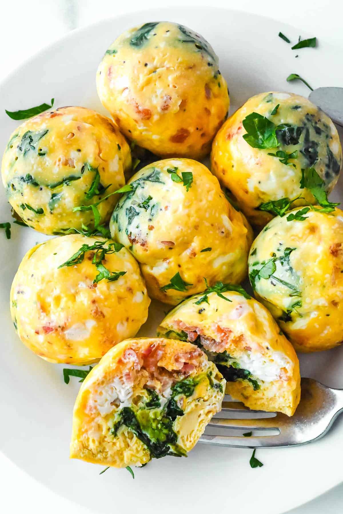 plate of egg bites with bacon and spinach.