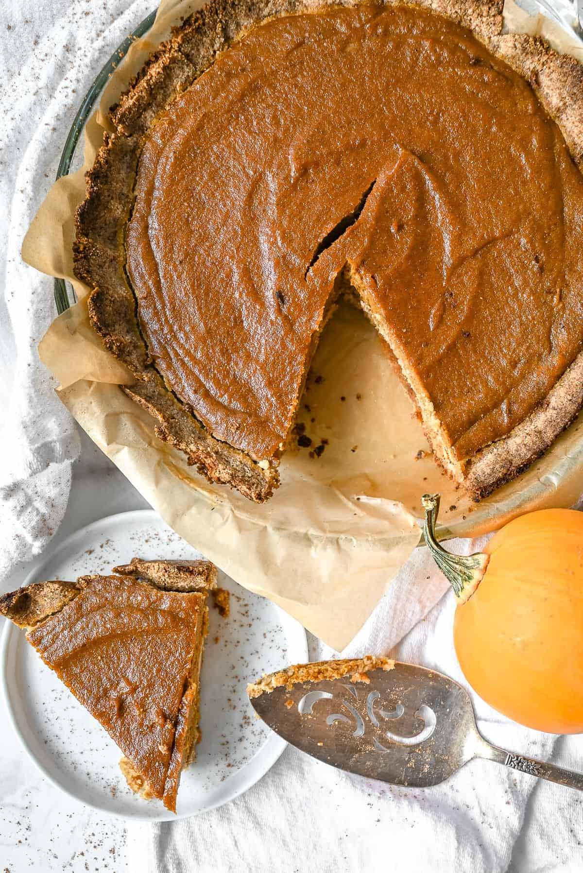 pumpkin pie made healthy and paleo in a pie plate and a slice on a plate
