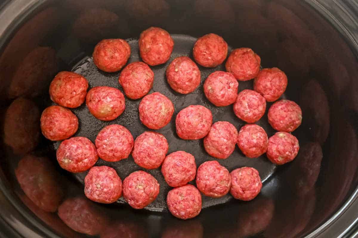 meatballs in a black crock pot.