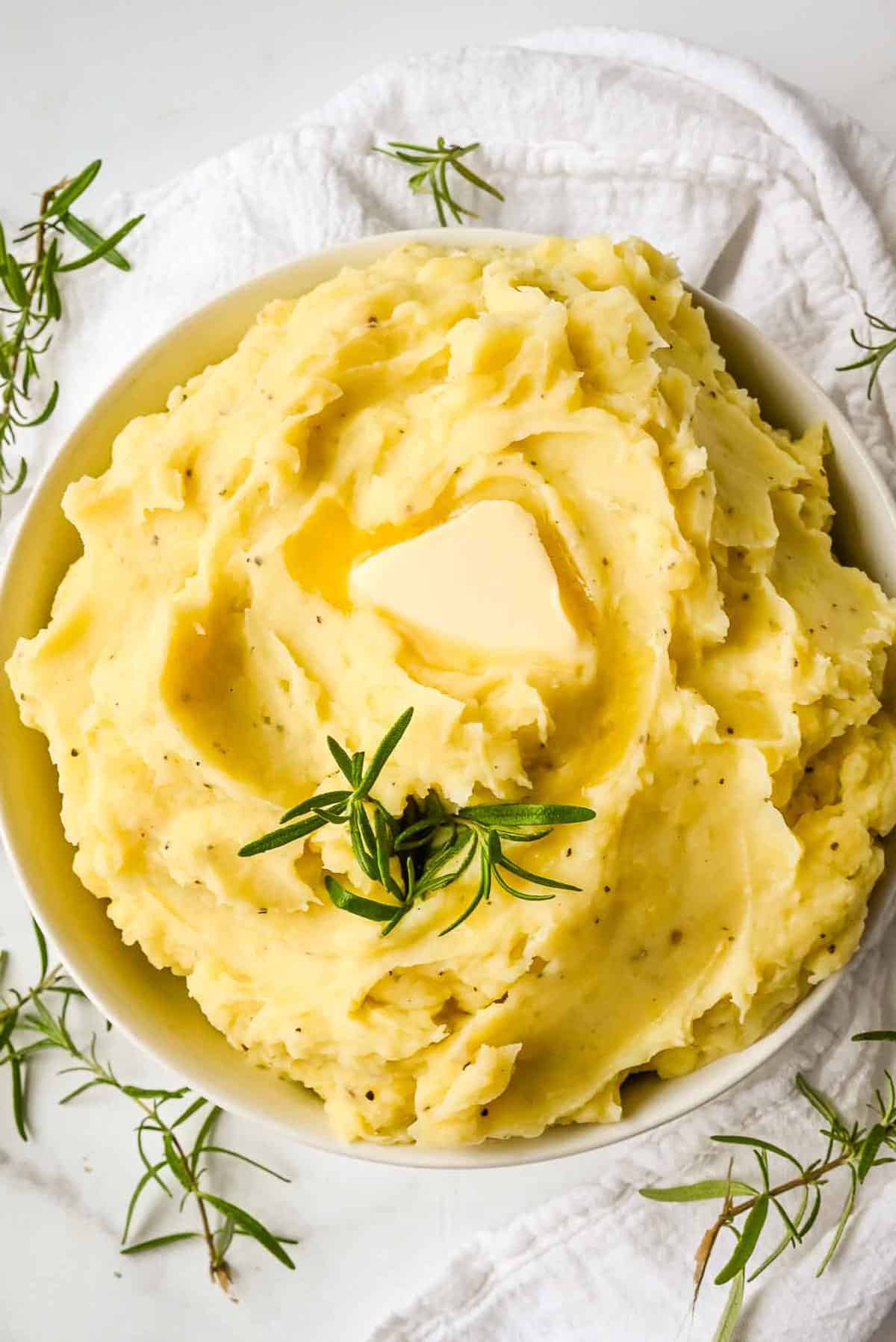 top down shot of dairy free mashed potatoes topped with butter and rosemary.