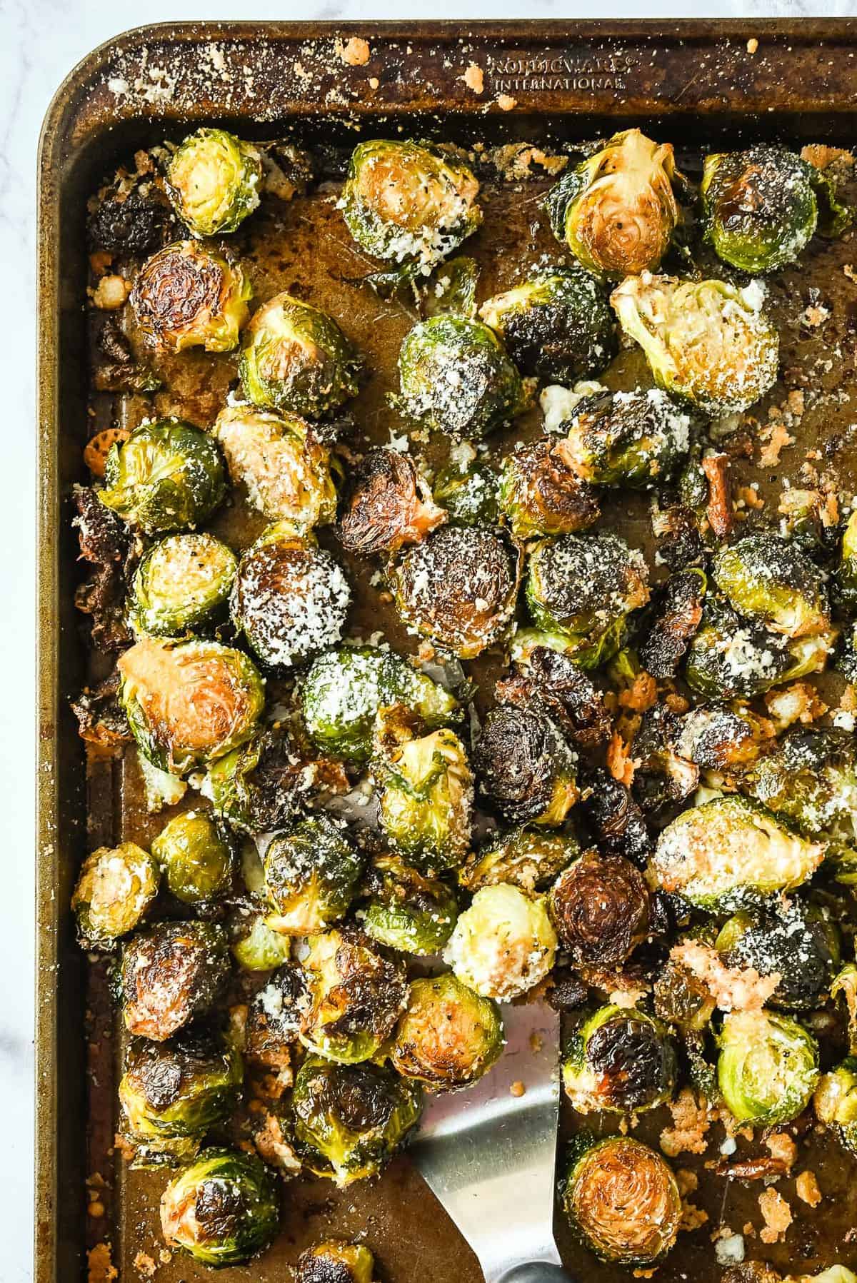 garlic parmesan brussel sprouts roasted on a sheet pan in the oven