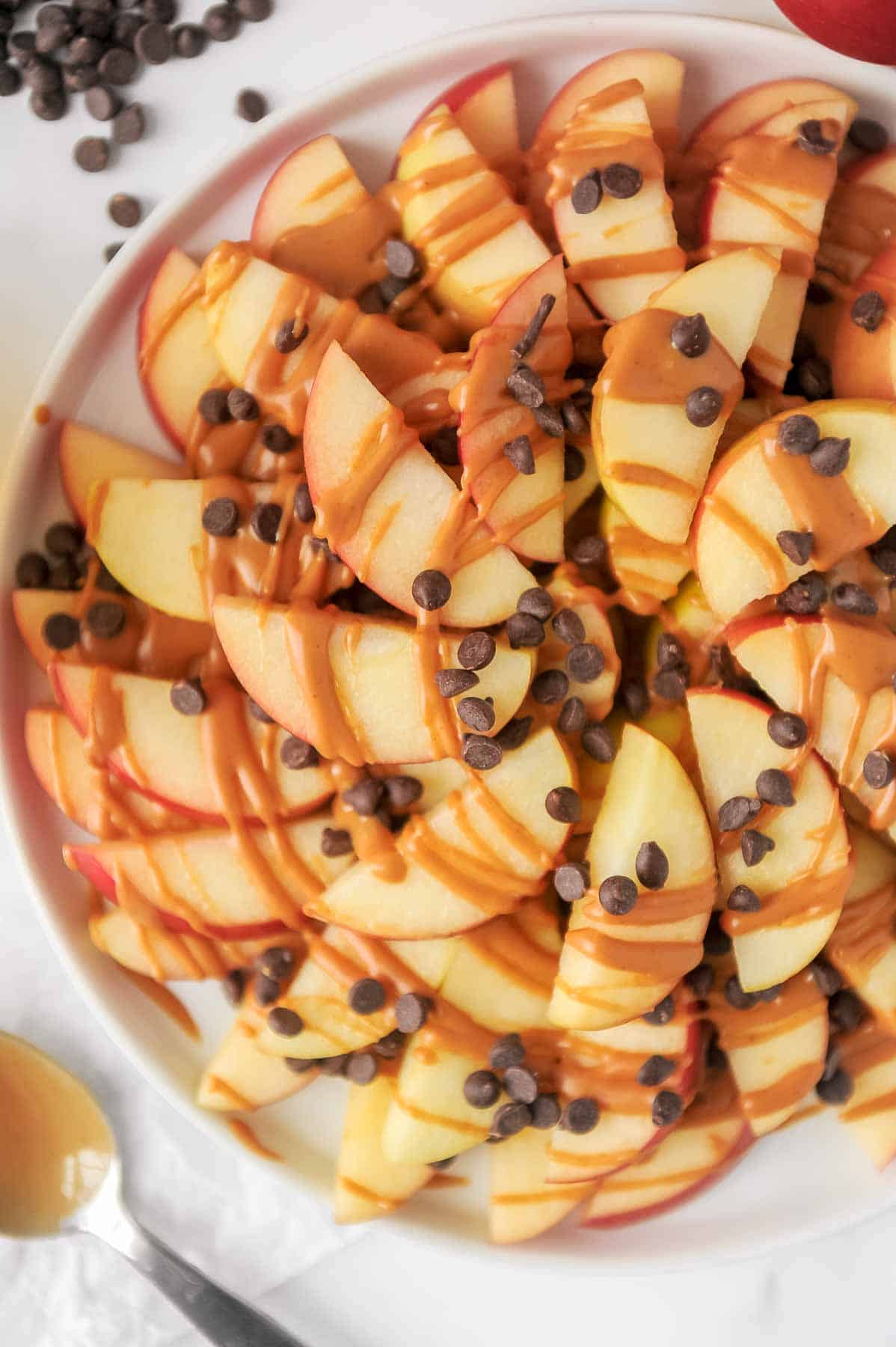 plate of apple nachos topped with peanut butter and chocolate chips