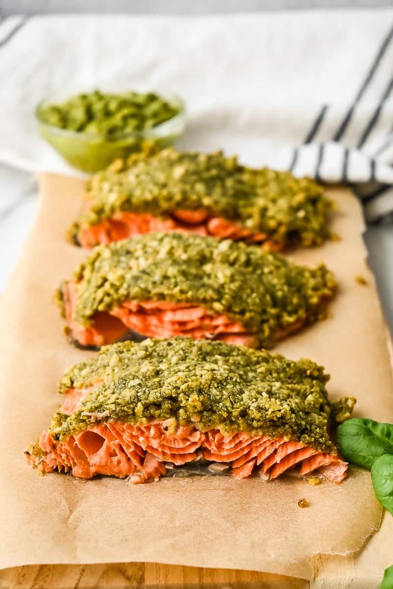 baked pesto crusted salmon filet on a board