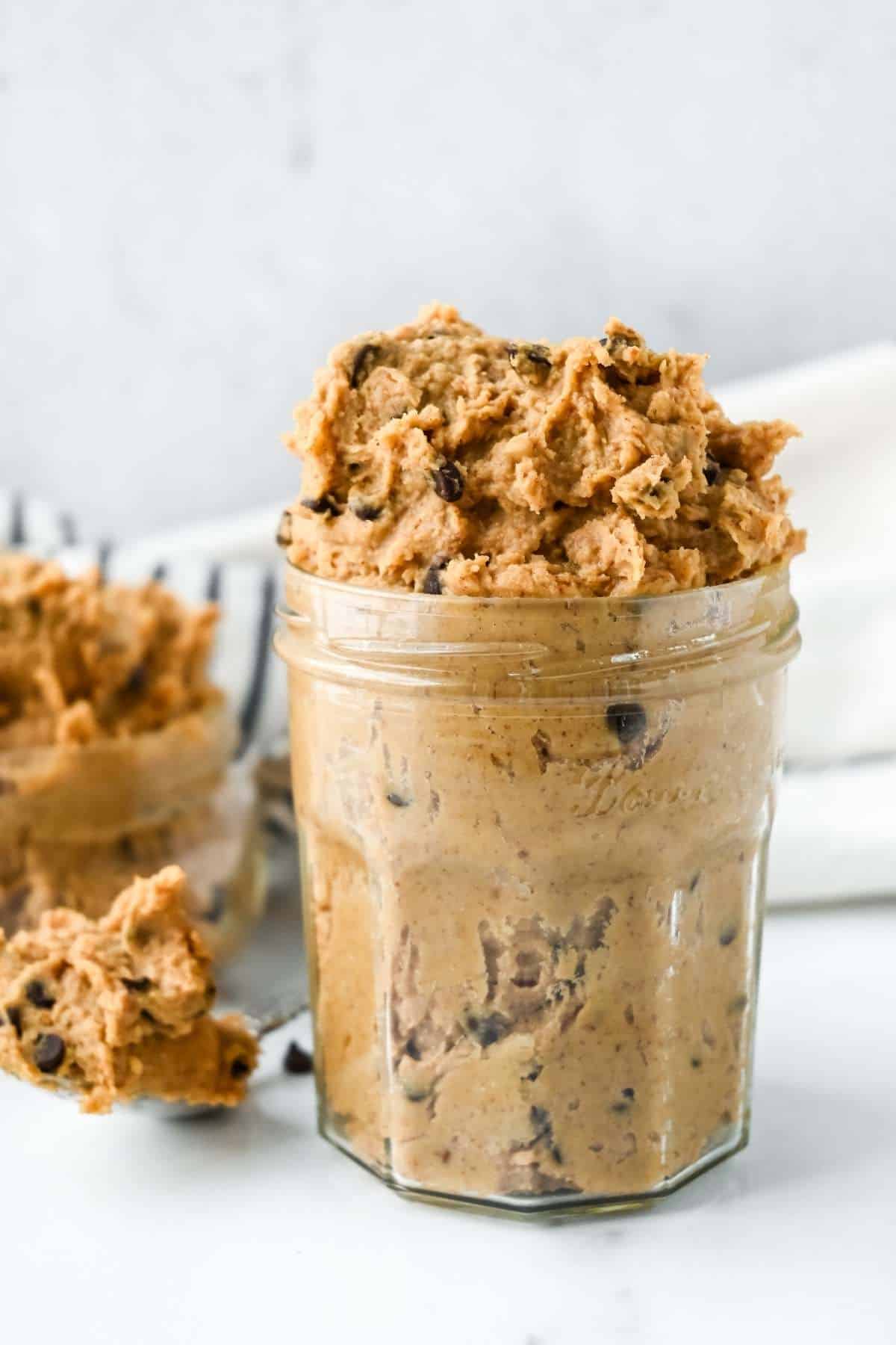 chocolate chip cookie dough hummus in a jar and on a spoon