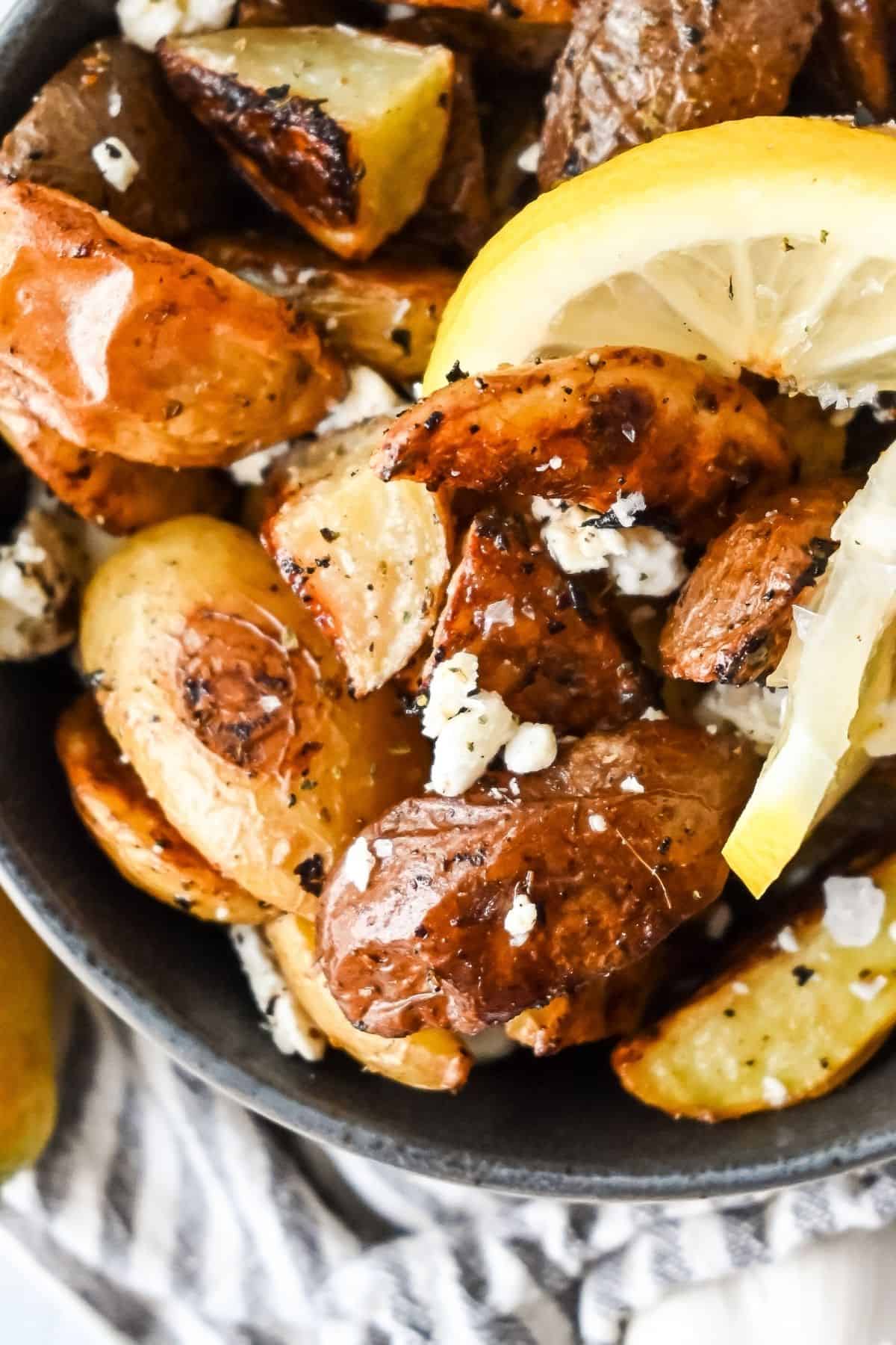 bowl of crispy Greek potatoes with lemon and with feta