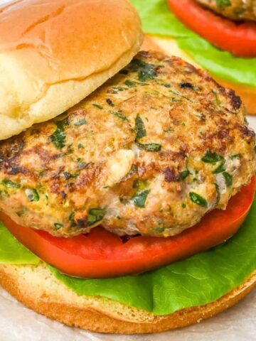 close up of turkey burger on a bun with lettuce and tomato with top bun offset.