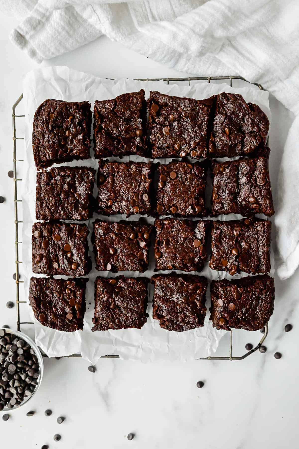 eggless brownies on a piece of parchment paper and a cooling rack