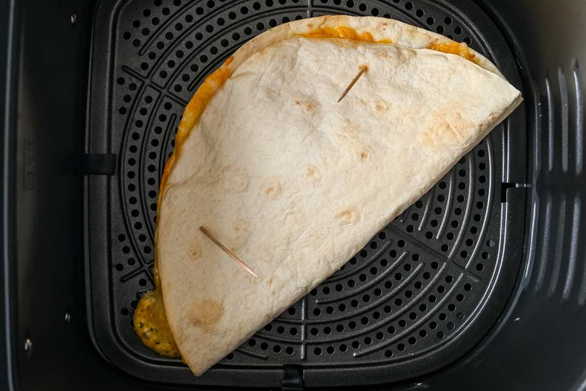 folded quesadilla in air fryer with toothpicks.