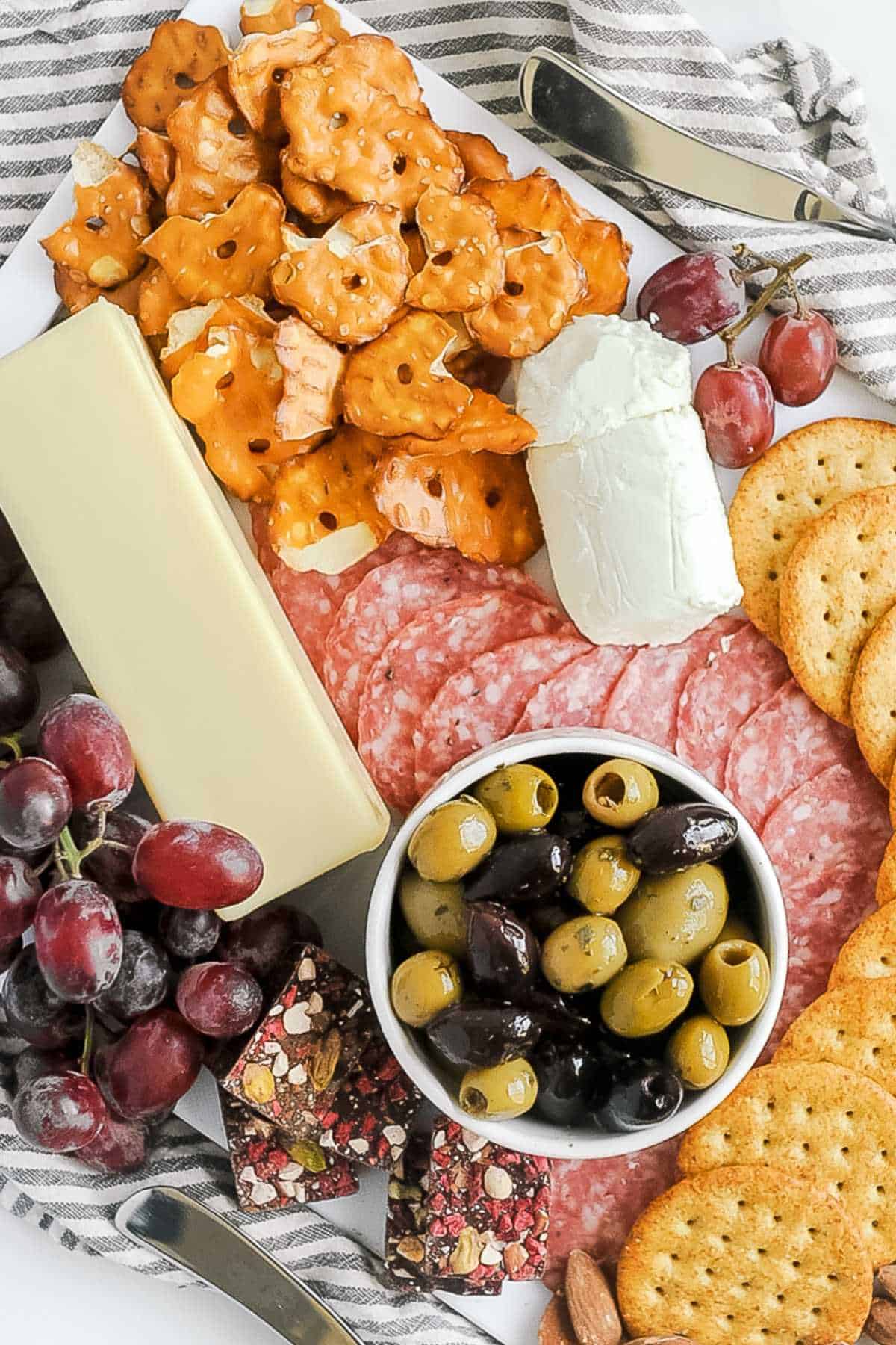 aldi charcuterie board featuring aldi meat and cheese selections on a large board with olives, grapes, and pretzels.