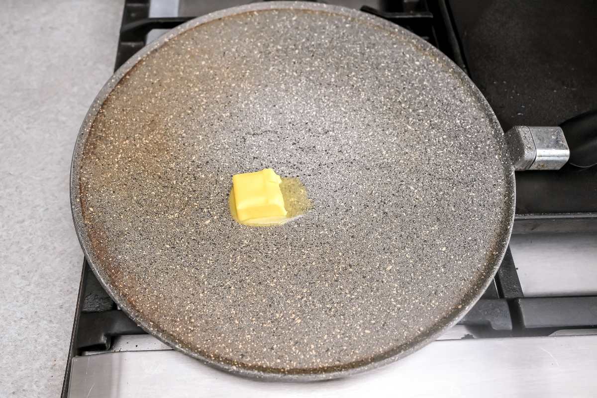butter melting on a gray pan on the stove.