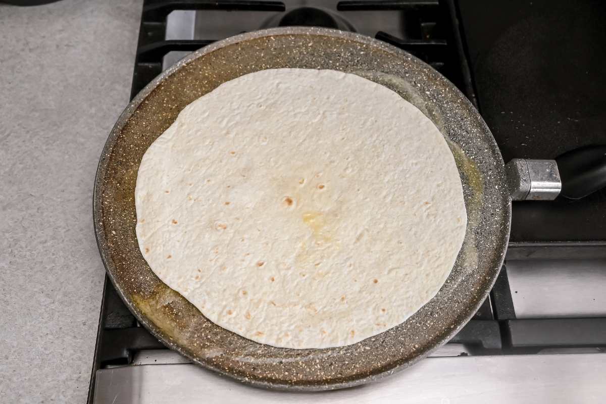 tortilla on a gray pan on the stove.