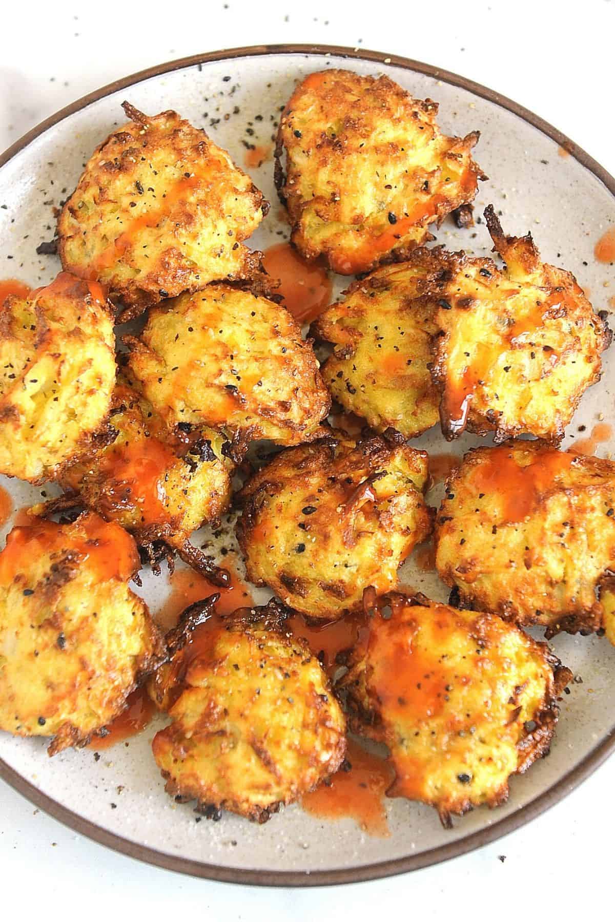 plate of air fryer hash browns with hot sauce