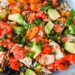 close up shot of southwest chicken bowl topped with cilantro and avocado.