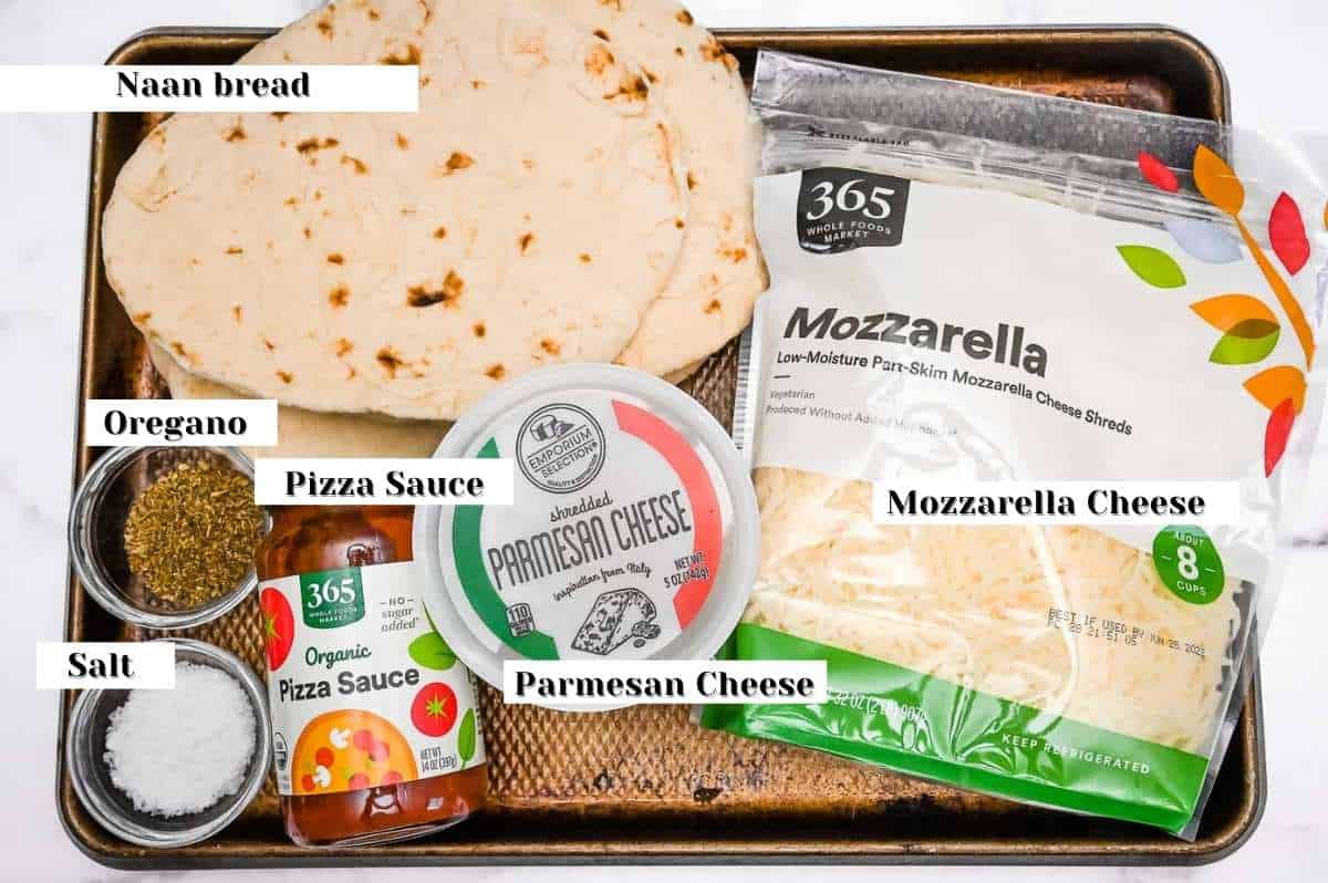 naan bread pizza ingredients on a sheet pan.