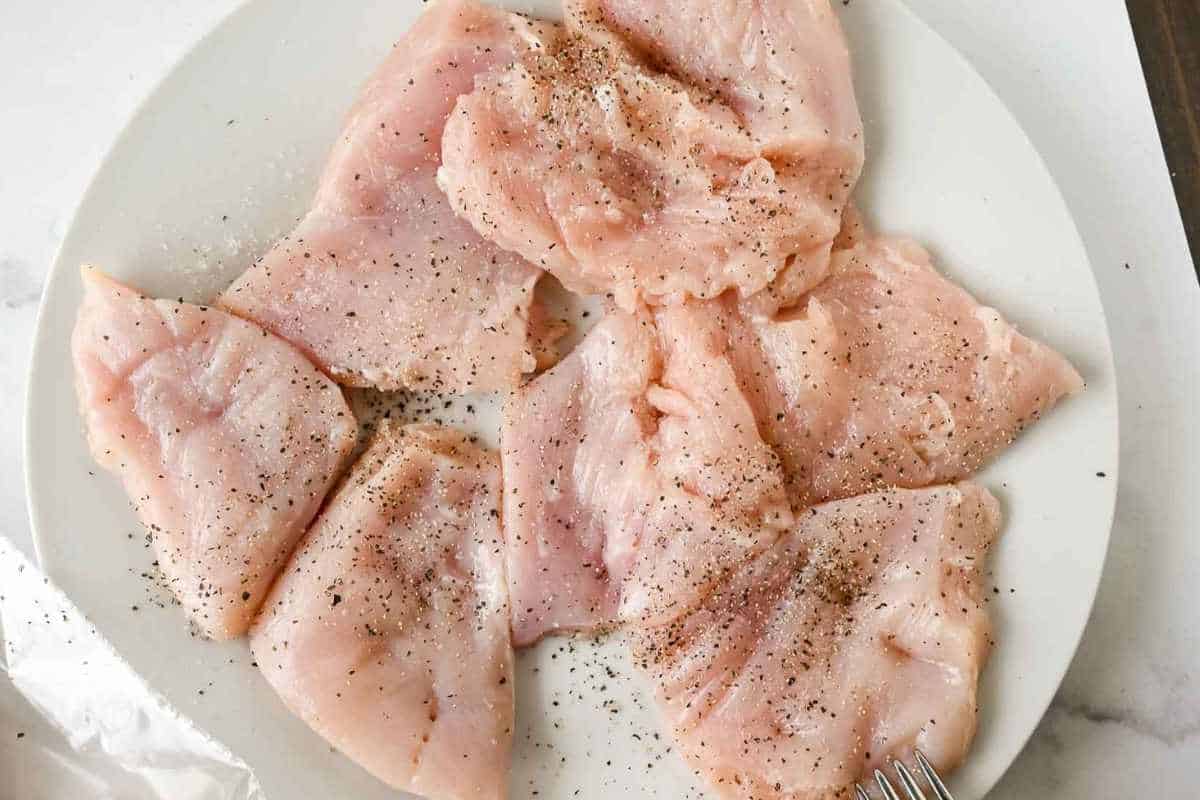 seasoned chicken breast on a white plate.