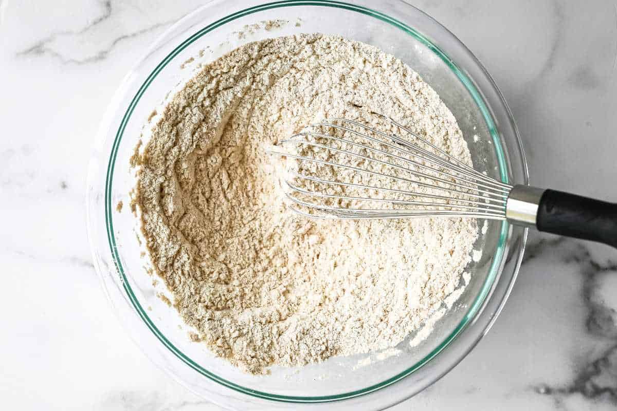recipe dry ingredients in a glass bowl with a whisk.