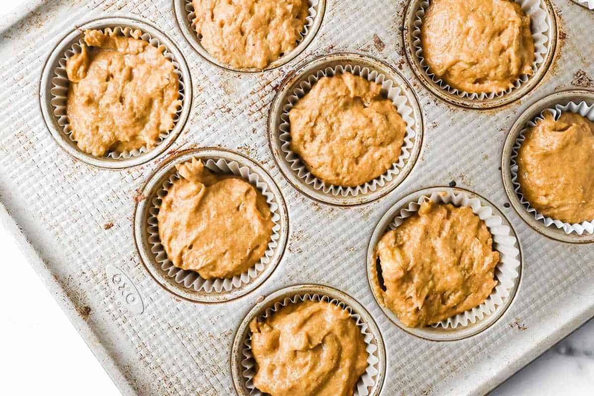 muffin tin with unbaked muffins.