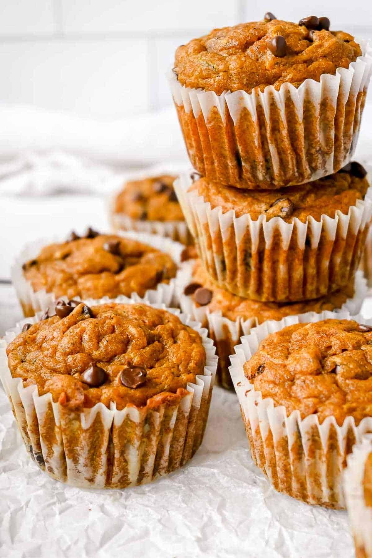 stack of pumpkin protein muffins on a white background.
