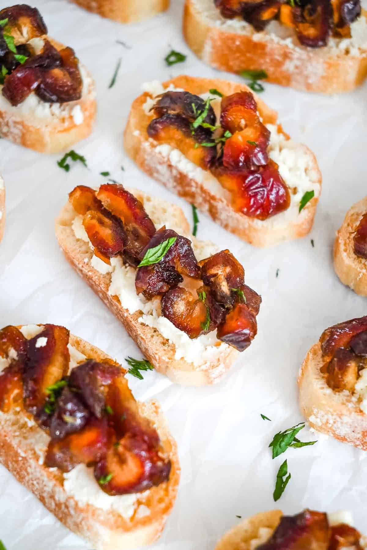 close up shot of goat cheese crostini on a white background.