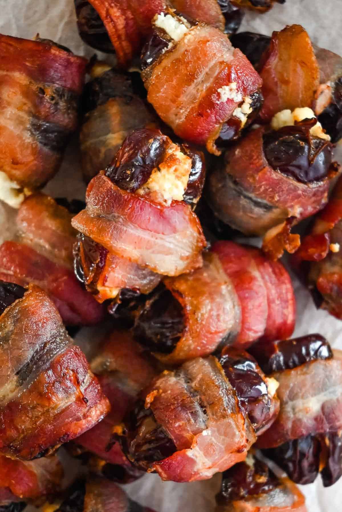 close up shot of goat cheese stuffed dates wrapped in bacon.