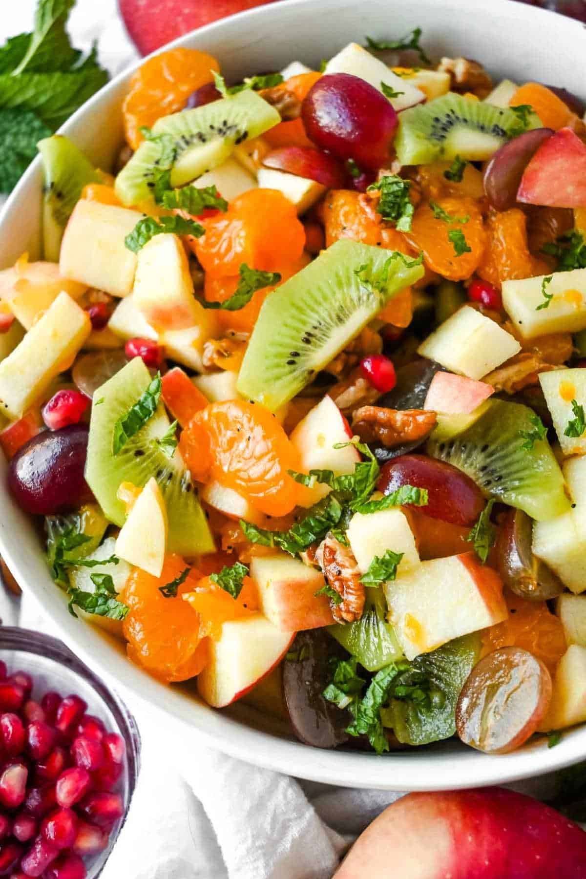 close up of thanksgiving fruit salad topped with lime vinaigrette and mint.