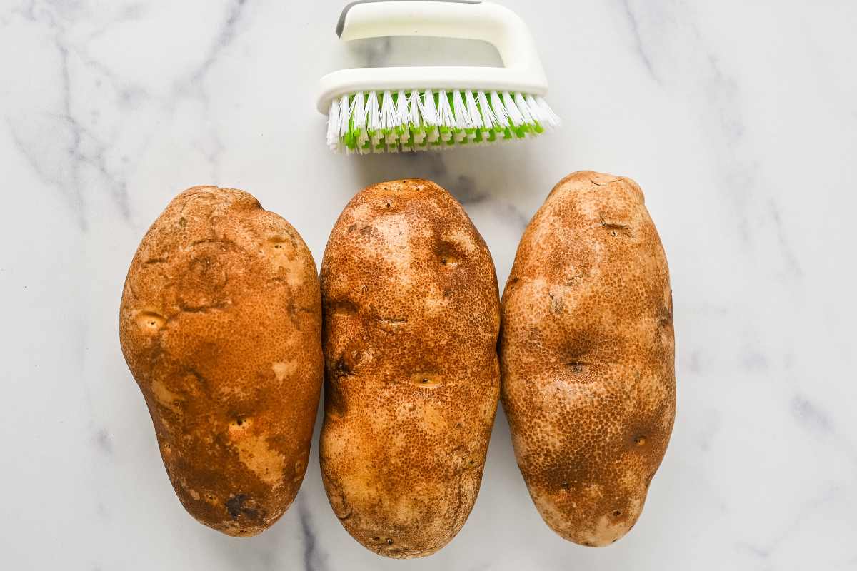 cleaned potatoes next to a vegetable brush.