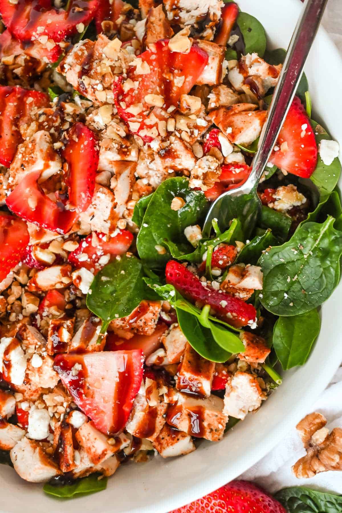 close up of spinach strawberry salad with goat cheese.