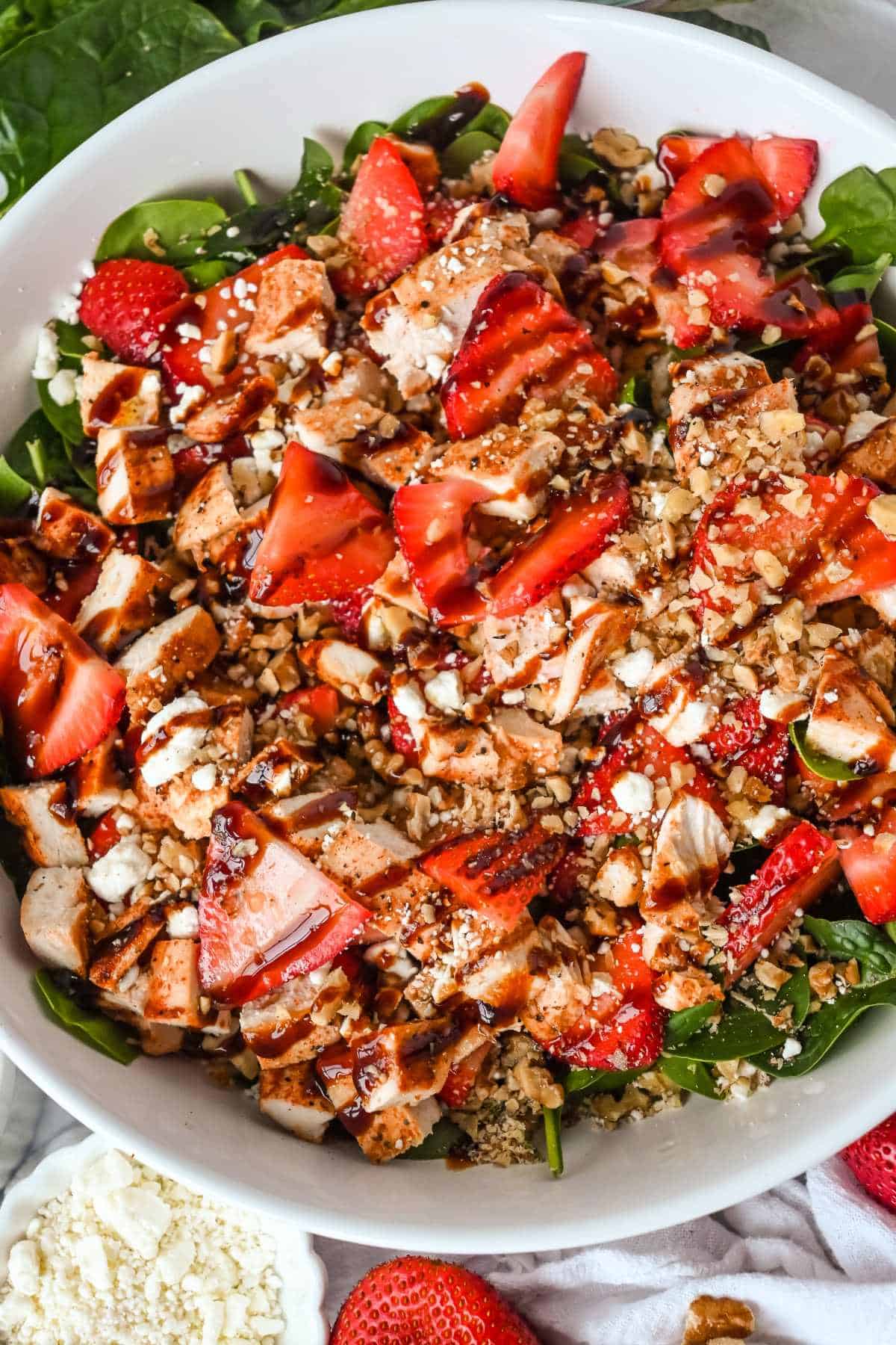 full shot of strawberry goat cheese salad in a white bowl.