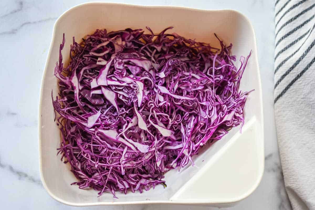 red shredded cabbage in a white colander.
