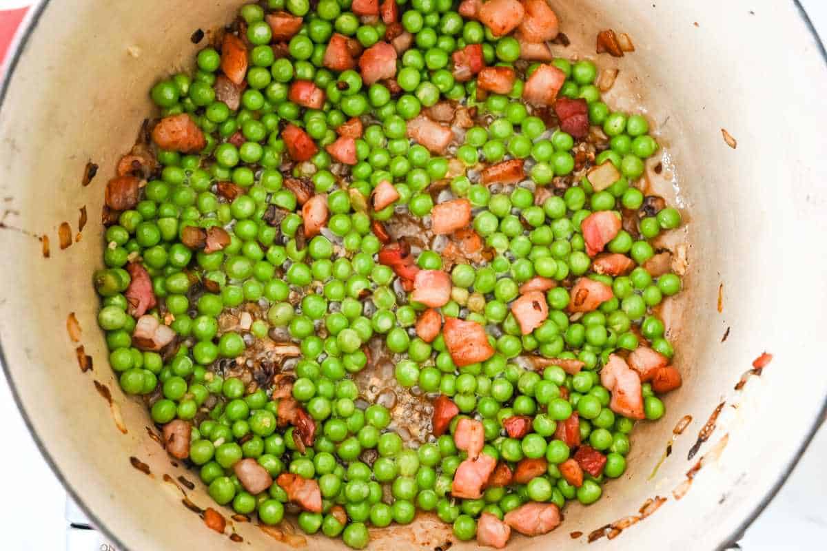 peas and pancetta cooking in a pan.