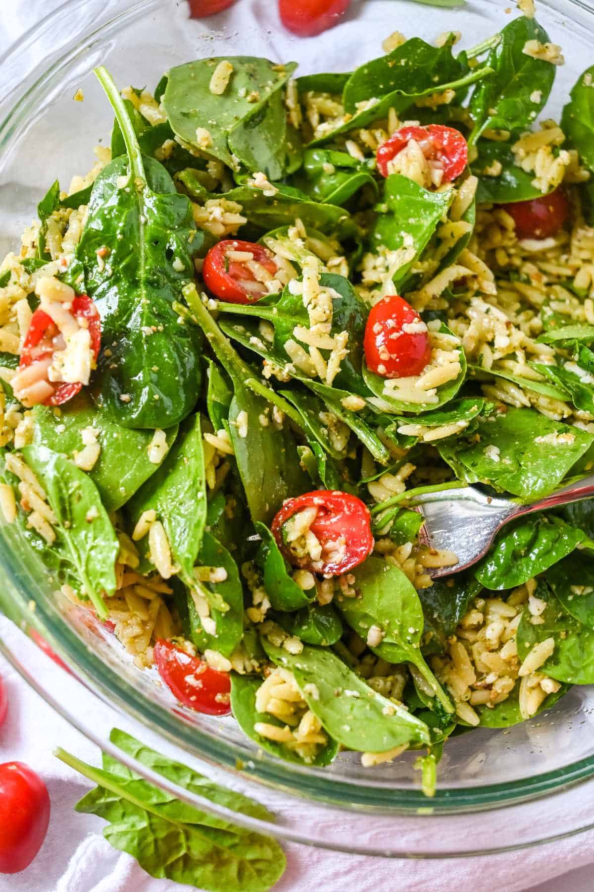 glass bowl of spinach orzo salad.