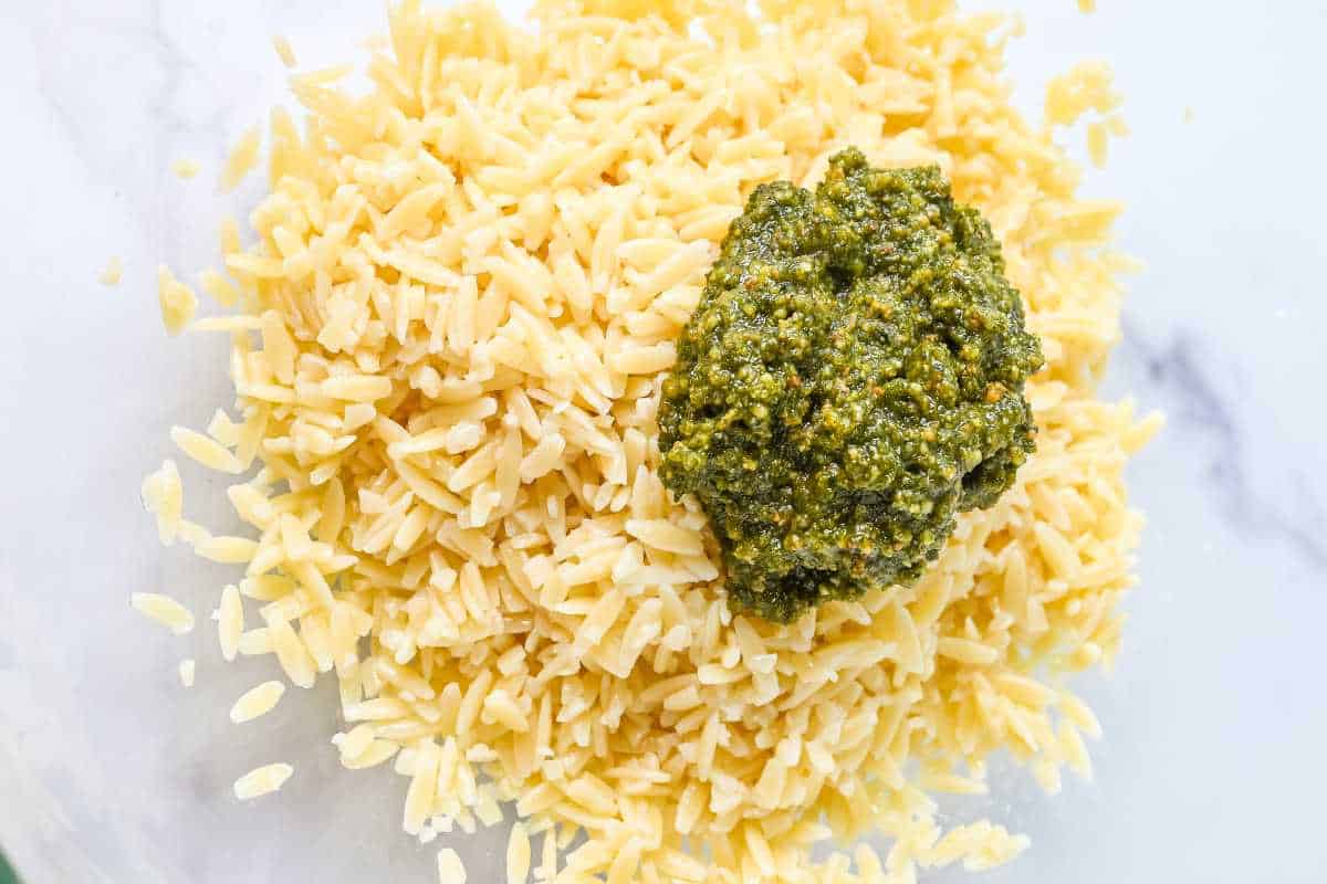 cooked orzo and pesto in a glass bowl.