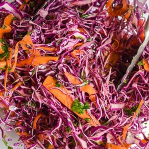 close up shot of red cabbage slaw with carrots and cilantro.