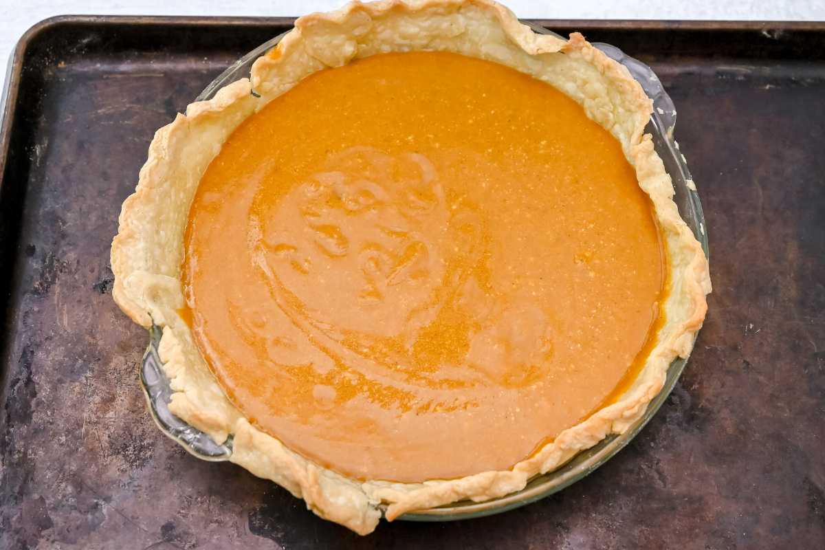 unbaked pumpkin pie on a sheet pan.