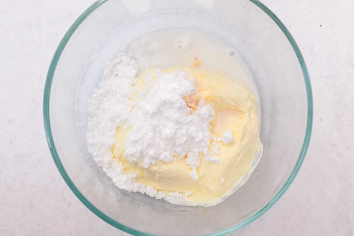 cream cheese filling ingredients in a glass bowl on a white background.
