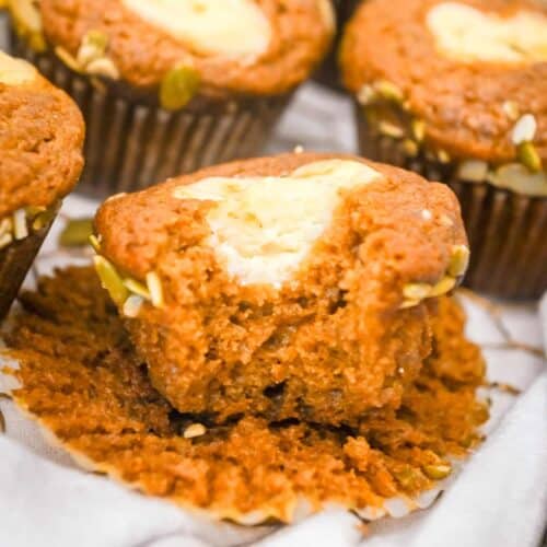 featured image of starbucks pumpkin muffins with a bite take out and topped with cream cheese filling.