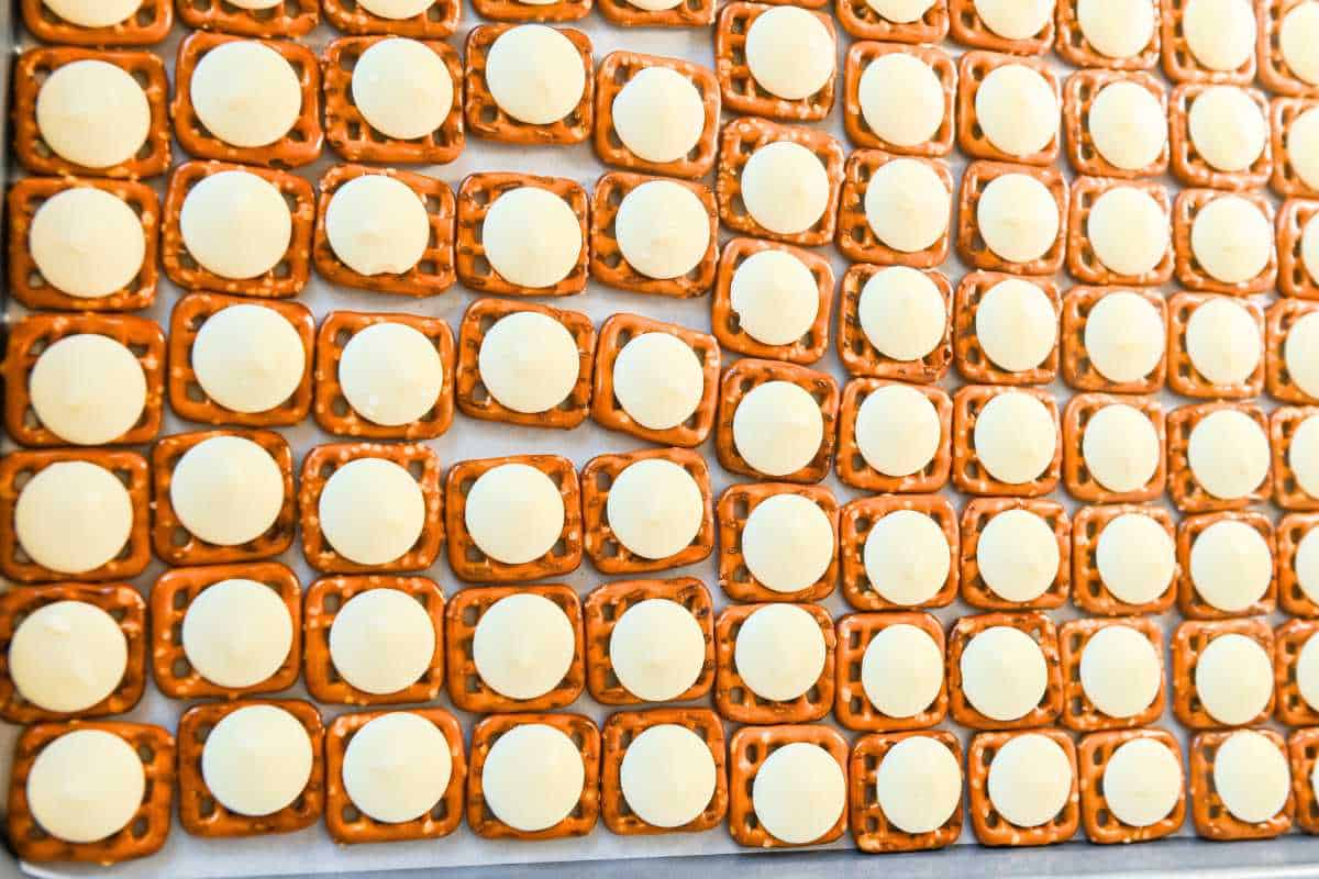 pretzels with white chocolate discs on a tray.