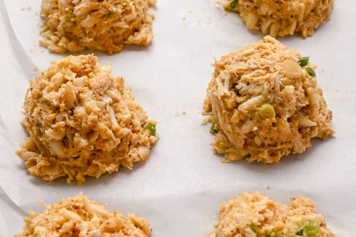 uncooked crab cakes on a sheet pan.
