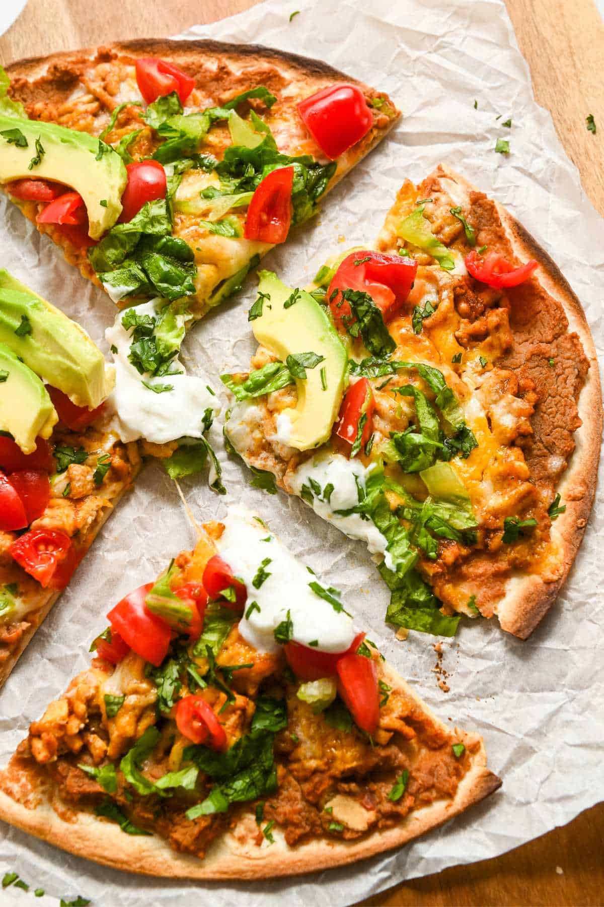 four slices of air fryer Mexican pizza on parchment paper.