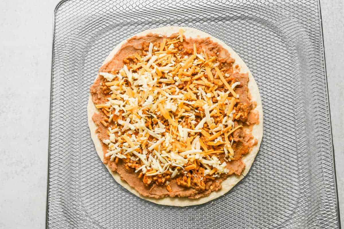uncooked air fryer Mexican pizza on an air fryer tray.